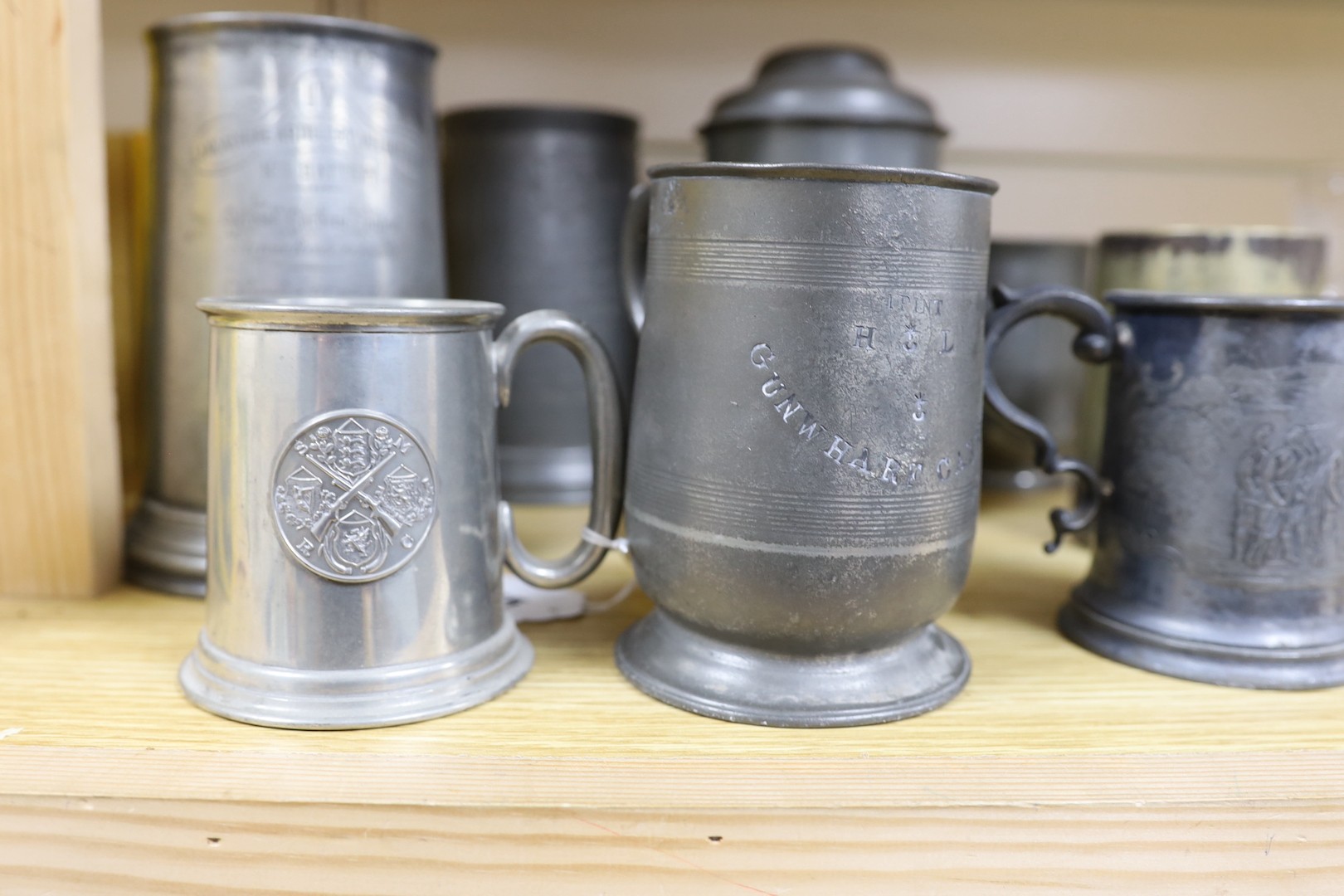 Seven pewter tankards relating to shooting clubs and artillery volunteers, and a smaller similar silver plated mug, tallest 21cm